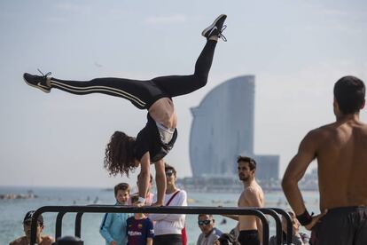 Una mujer hace gimnasia en una playa de Barcelona.