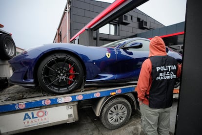 A police officer looks on as a luxury vehicle which was seized in a case against media influencer Andrew Tate, is towed away, on the outskirts of Bucharest, Romania, Saturday, Jan. 14 2023.