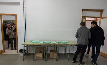 Varios jóvenes, tras escoger papeleta en un colegio electoral sevillano, el 2 de diciembre.