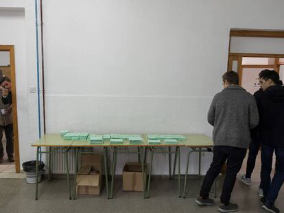 Varios jóvenes, tras escoger papeleta en un colegio electoral sevillano, el 2 de diciembre.