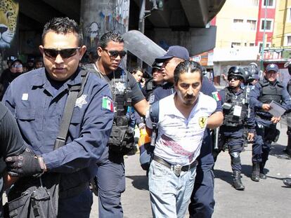 Agentes estatales detienen a maestros disidentes durante una protesta en Morelia, Michoac&aacute;n.