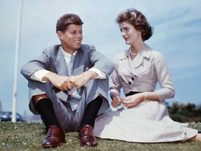 John F. Kennedy y Jacqueline Bouvier sentados en el jardín de la casa de la familia Kennedy unos meses antes de celebrar su boda.