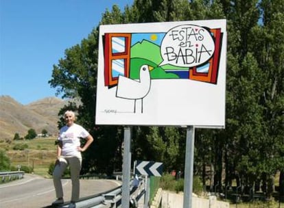 Retrato de la autora del texto, Cristina Fernández Pérez, frente a un cartel que anuncia la comarca de Babia, en la montaña de León.
