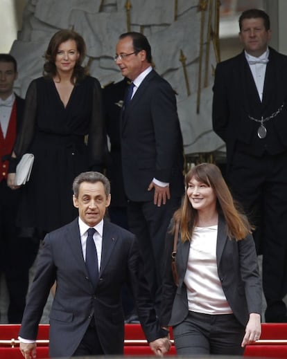 El expresidente Nicolas Sarkozy sale del palacio del Elíseo acompañado de Carla Bruni tras la ceremonia de traspaso de poder. Detrás Hollande y su compañera Valerie Trierweiler, quienes han acompañado hasta las escaleras a la pareja saliente.