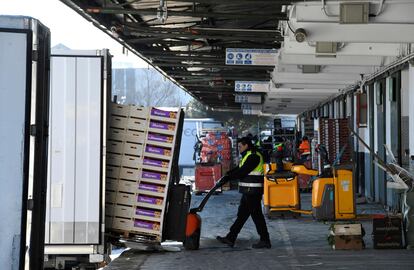 Descarga de los camiones repletos de frutas llegados a los hangares de Mercamadrid.