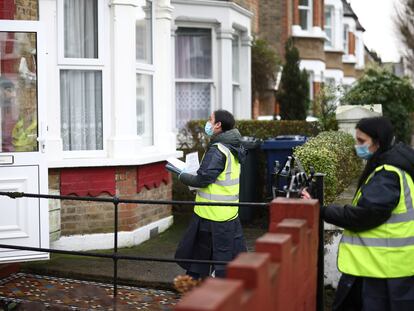 Dos voluntarias entregan puerta a puerta test caseros para hacerse la prueba del coronavirus, en Londres, este miércoles.