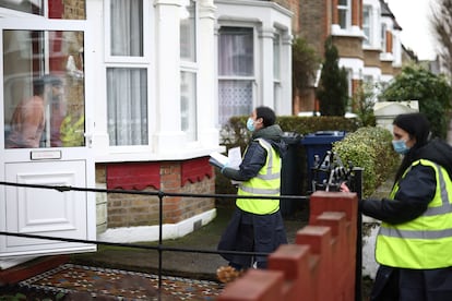 Dos voluntarias entregan puerta a puerta test caseros para hacerse la prueba del coronavirus, en Londres, este miércoles.