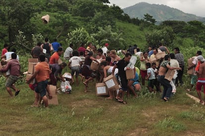 Las víctimas de las inundaciones reciben las cajas de provisiones del helicóptero de la Marina de México, en el área de Acapulco, en el Estado de Guerrero, México.