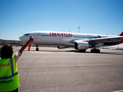 Una empleada de Iberia da el visto bueno a las operaciones en pista de un avión de la aerolínea.
