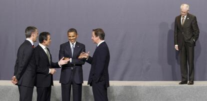 Herman Van Rompuy, presidente del Consejo Europeo, permanece al margen mientras otros participantes en una cumbre de la OTAN charlan con Obama.