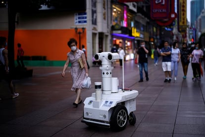 Un robot policía patrulla una calle comercial de Shanghái en junio de 2020.