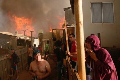 Al menos 6.000 personas han sido evacuadas a causa de un incendio registrado en los alrededores de la localidad chilena de Viña del Mar, en la región de Valparaíso (Chile). En la imagen, algunos residentes de Viña del Mar trabajan para evitar que el fuego se extienda a sus casas.