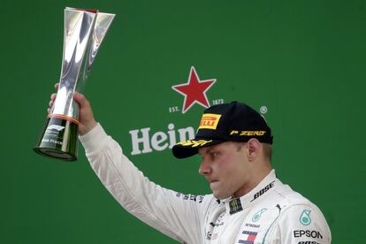 El piloto finlandés Valtteri Bottas levanta su trofeo después de conseguir la segunda plaza.