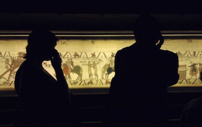 Dos personas miran uno de los tramos del Tapiz de Bayeux.