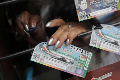 Una vendedora de boletos de lotería muestra el "cachito" del avión presidencial, en septiembre del 2020 en Ciudad de México.