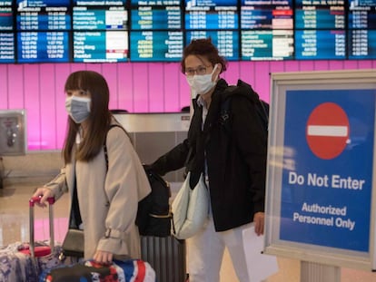 Passageiros com máscaras ao desembarcarem no aeroporto de Los Angeles, na quarta-feira.