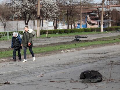 Una mujer y su hijo pasaban el sábado junto a un cadáver en Mariupol.