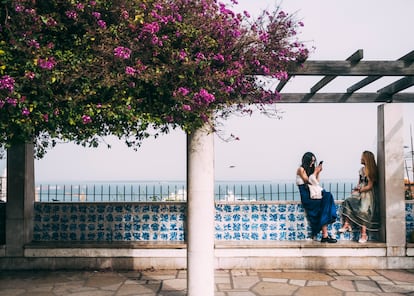 Dos mujeres en el mirador de Santa Lucía, con vistas a la ciudad de Lisboa y el Tajo.