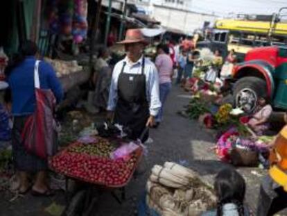 Un hombre ofrece frutas en el Mercado "La Terminal", en la Ciudad de Guatemala, durante la conmemoración del Día Internacional del Trabajo.