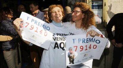 Unas mujeres se felicitan con las copias del n&uacute;mero 79.140, agraciado con el Gordo de Navidad vendido &iacute;ntegramente en la administracion n&ordm; 2 de Roquetas de Mar, Almer&iacute;a.
 
 