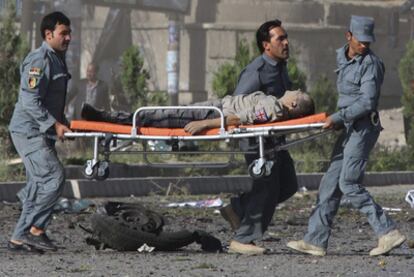 Policías afganos trasladan a un británico herido del lugar donde se ha producido una explosión.