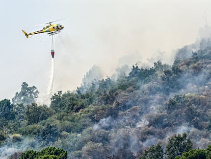 Un helicóptero trabaja en las labores de extinción del incendio en Mombeltrán (Ávila), este jueves.