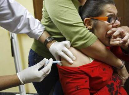 Una mujer recibe la vacuna de la nueva gripe en el centro de salud Puerta Blanca (Málaga).
