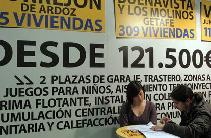 Una pareja joven consulta unos folletos en el Salón de la Vivienda Social, Asequible y Sostenible en el Pabellón de Convenciones de la Casa de Campo de Madrid.
