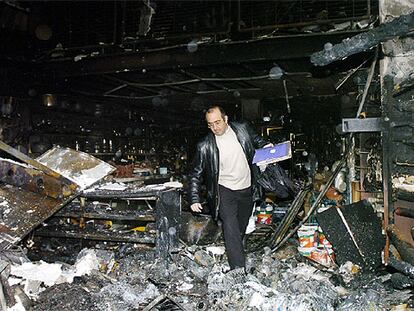 El concejal de UPN José Antonio Mendive inspecciona los restos calcinados de su ferretería.