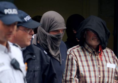 ETA member Juan Maria Mugica Dorronsoro (R), is escorted by policemen as he leaves the court following a hearing on Thursday in Pau, southwestern France.