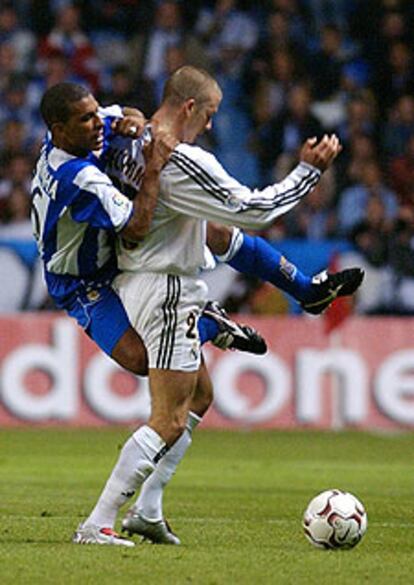El centrocampista del Deportivo Djalminha agarra a Beckham en una disputa por el control del balón.
