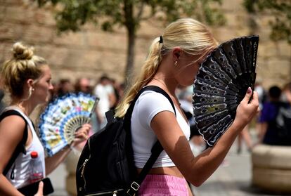 La mínima más alta del país se registró el lunes en Osuna (Sevilla), donde los termómetros no bajaron de 27,4°. También se produjeron noches tórridas, por encima de 25°, en otros puntos de Andalucía y de Extremadura. Son unas máximas entre 7° y 12° por encima del promedio normal de esta época, y las mínimas, entre 4° y 13°. En la imagen, dos mujeres utilizan abanicos para combatir las altas temperaturas en Sevilla, el pasado lunes. 