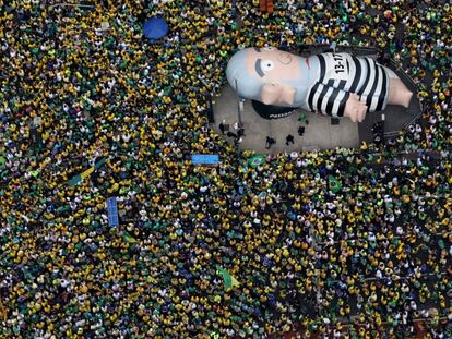 Manifestantes levantam o boneco que remete ao ex-presidente Lula, na avenida Paulista, no domingo (13).