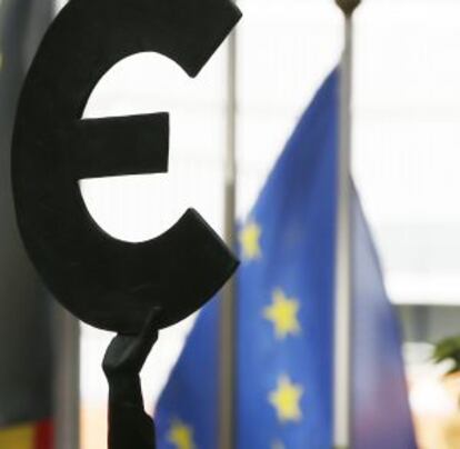 Una estatua junto a la bandera europea en la entrada del Parlamento Europeo en Bruselas