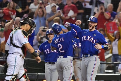 Los jugadores de Texas festejan, al fondo, frente al 'catcher' de Arizona.