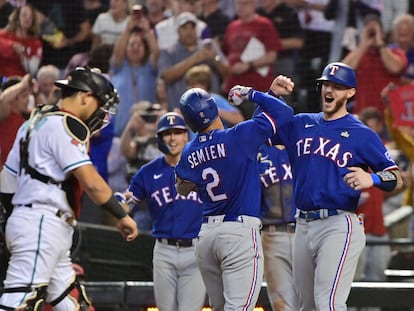 Los jugadores de Texas festejan, al fondo, frente al 'catcher' de Arizona.