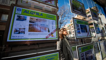 Una joven mira los anuncios de viviendas en venta y alquiler de una inmobiliaria en Madrid, el 27 de febrero.
