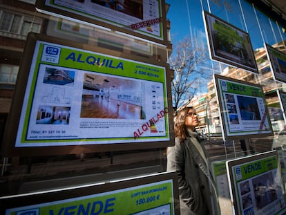 Una joven observa la oferta de pisos en alquiler de una oficina inmobiliaria de Madrid.