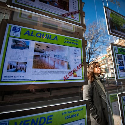 Una joven observa la oferta de pisos en alquiler de una oficina inmobiliaria de Madrid.