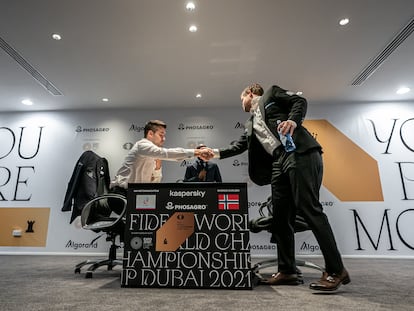 Carlsen, de pie, saluda a Niepómiashi cuando llega al escenario para disputar la 9ª partida del Mundial de Dubái