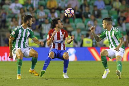 El jugador del Atco de Madrid, Gait‡n (c ) controla un balón a cabeza ante los jugadores del Betis, Cejudo (i) y Alex Martínez (d).
