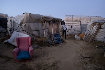 A field worker walks between shacks at the makeshift camp in Lepe.