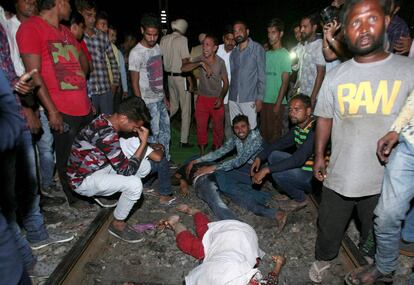 Varios de los asistentes a la festividad hindú rodean a algunos de los fallecidos.