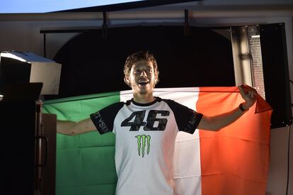Rossi posa sonriente con la bandera italiana.