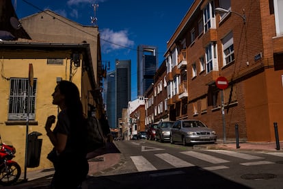 Una mujer camina por la calle Cañaveral de Madrid, con las Cuatro Torres al fondo.