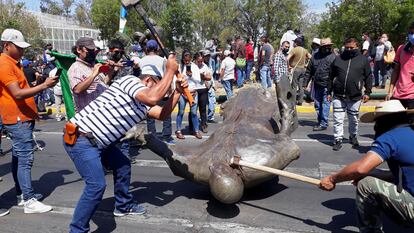 Miembros del Consejo Indígena destruyen la estatua de Fray Antonio de San Miguel en Morelia, el lunes.