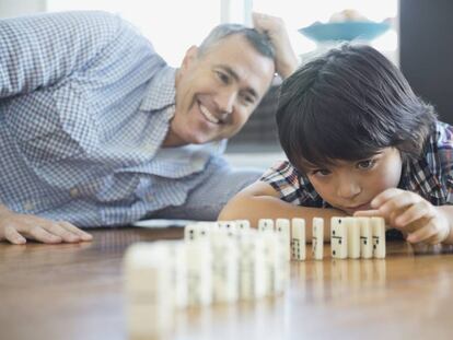 Un padre juega al dominó con su hijo. 