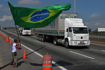 La huelga de camioneros brasileños contra el aumento del precio del diésel comenzó a perder fuerza después de ocho días de bloqueos que paralizaron a la mayor economía de América Latina y sacudieron a su impopular gobierno. En la imagen, un manifestante con la bandera nacional de Brasil en el exterior de unarefinería en Río de Janeiro, el 28 de mayo de 2018.