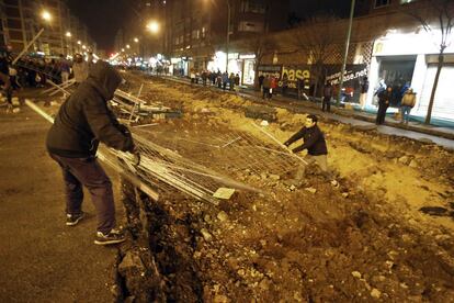 Unos vecinos tiran las vallas que separan las obras en el barrio del Gamonal en Burgos.