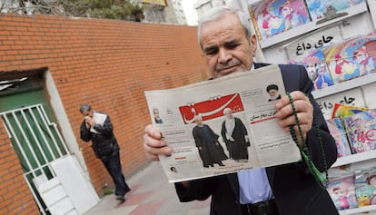 Un hombre sostiene un periódico, este domingo en Teherán, con las imágenes de Rafsanjani y Rohaní.